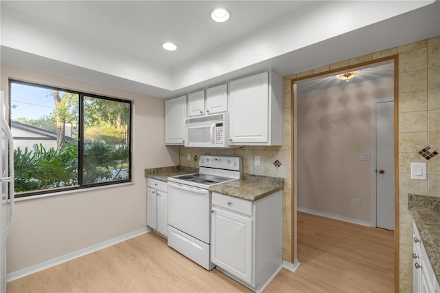 3856 NE 19th Street Cir, Ocala, FL 34470 - kitchen featuring white appliances, white cabinetry, baseboards, and light wood-style flooring