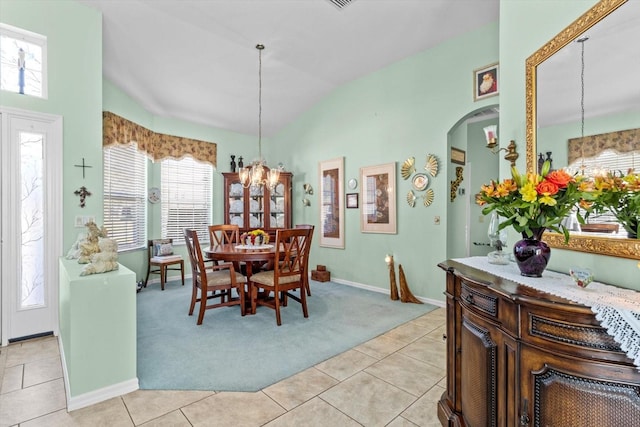 dining area featuring lofted ceiling, light tile patterned floors, and a notable chandelier