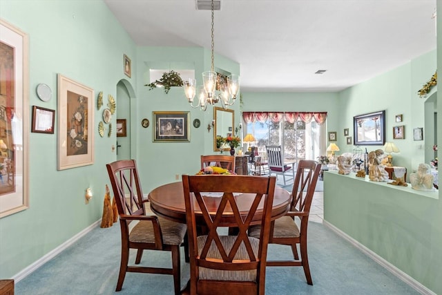 carpeted dining space with a chandelier