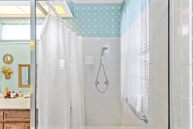 bathroom featuring walk in shower and vanity