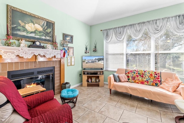 living room with a brick fireplace and light tile patterned flooring