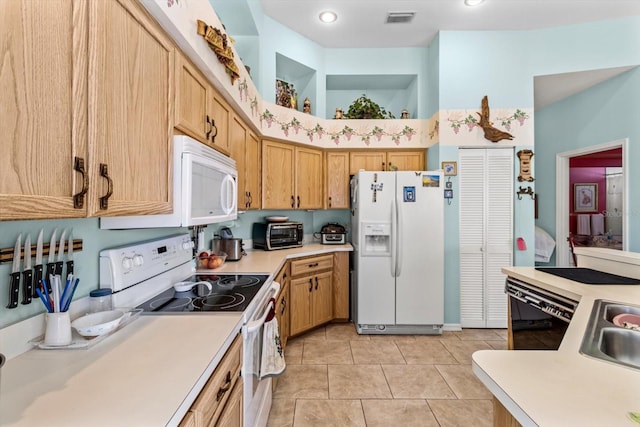 kitchen featuring white appliances, light tile patterned floors, and light brown cabinets