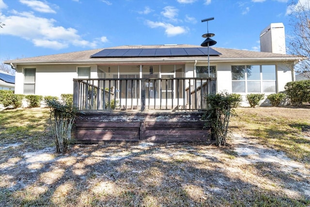 rear view of property featuring solar panels and a porch