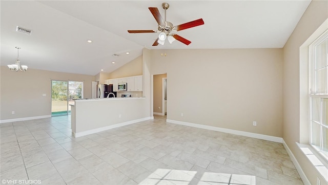 unfurnished living room with ceiling fan with notable chandelier and high vaulted ceiling