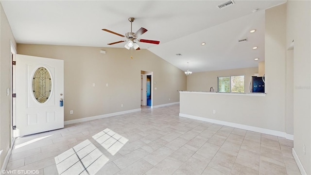 interior space with vaulted ceiling, light tile patterned flooring, and ceiling fan with notable chandelier