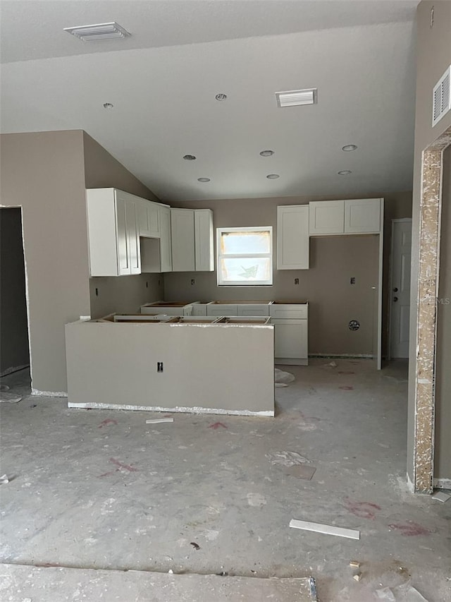 kitchen featuring white cabinetry and lofted ceiling