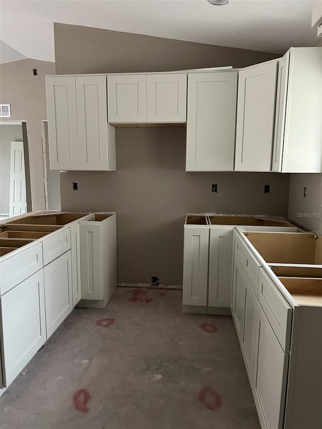 kitchen with white cabinetry and lofted ceiling