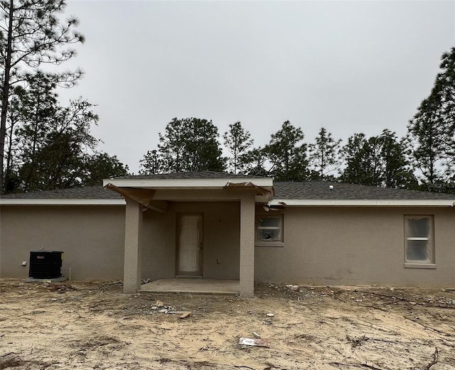 rear view of property with central AC unit and a patio