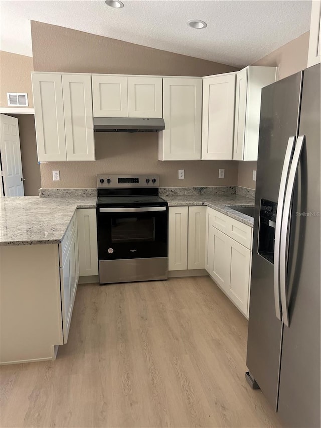 kitchen featuring white cabinetry, light stone counters, vaulted ceiling, and stainless steel appliances