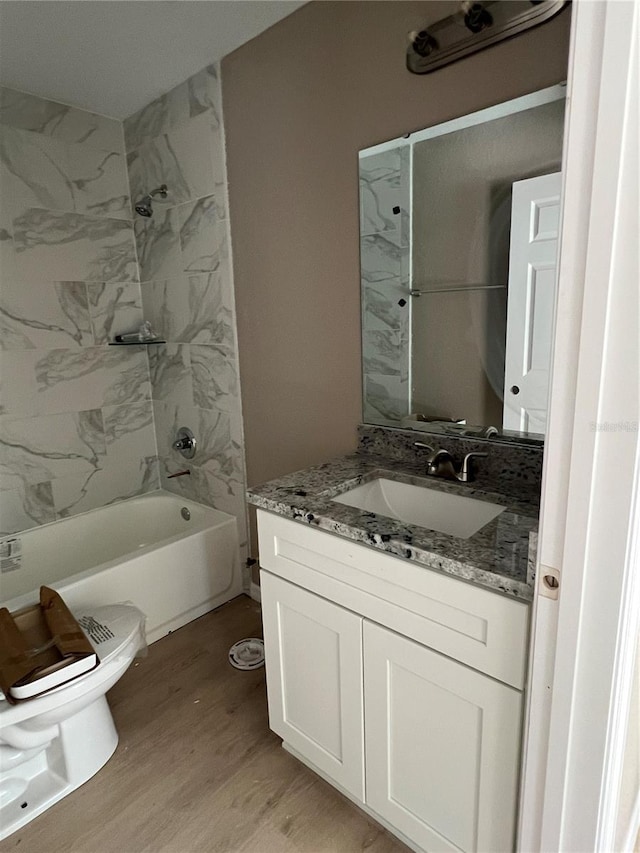 full bathroom featuring vanity, toilet, tiled shower / bath combo, and hardwood / wood-style floors