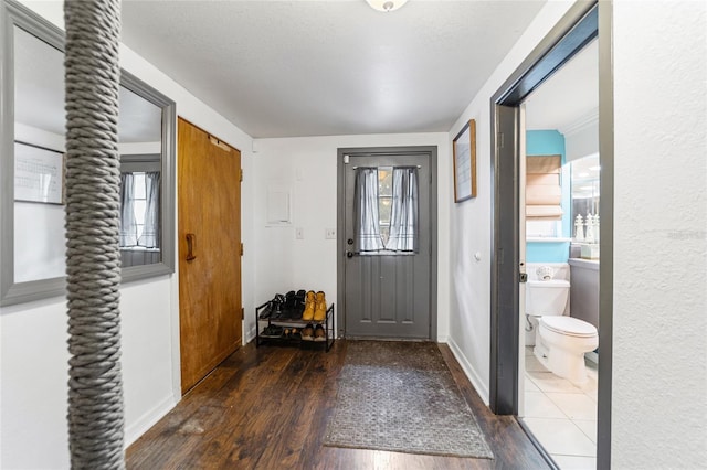 entryway featuring baseboards and wood finished floors