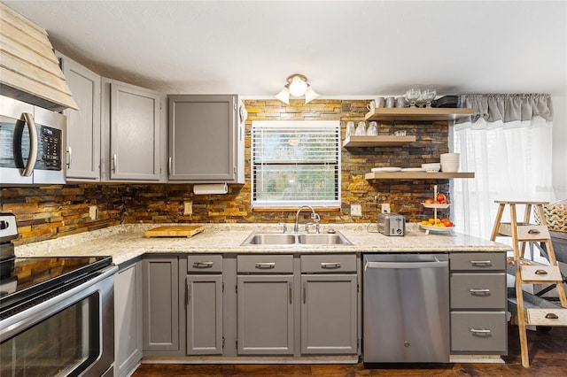 kitchen featuring a sink, open shelves, stainless steel appliances, and gray cabinetry