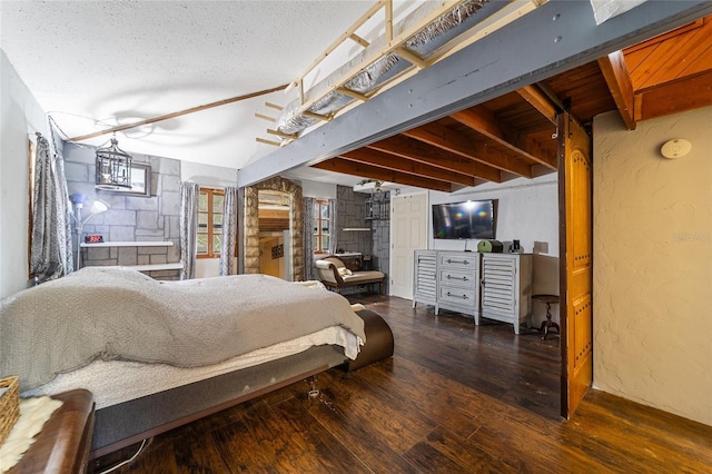 bedroom with beamed ceiling, a textured ceiling, a textured wall, and hardwood / wood-style floors