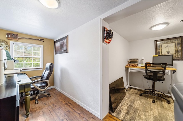 office space featuring baseboards, a textured ceiling, and wood finished floors