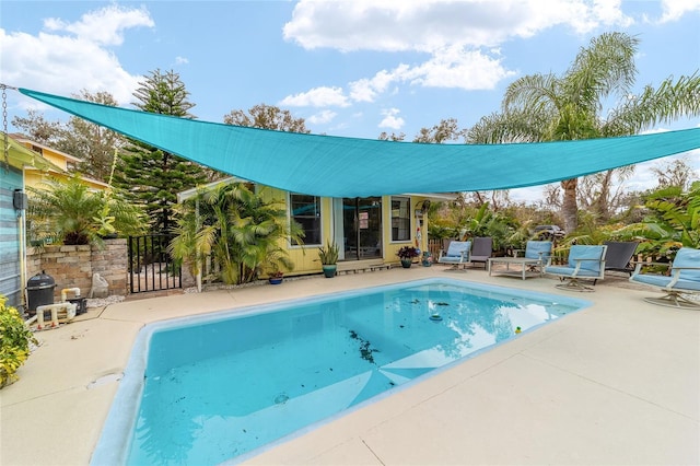 outdoor pool featuring a gate, an outdoor structure, and a patio area