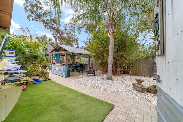 view of yard with a gazebo, a patio, an outdoor fire pit, and a fenced backyard