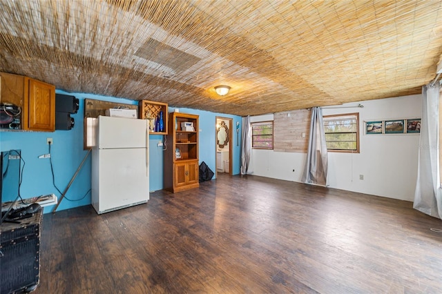 interior space featuring brown cabinets, wood ceiling, dark wood finished floors, and freestanding refrigerator