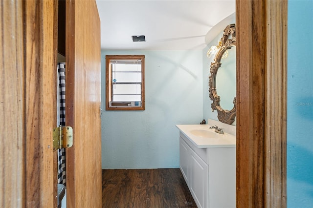 half bath featuring wood finished floors and vanity