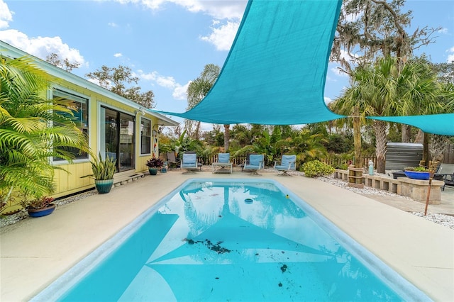 outdoor pool with a patio area and fence