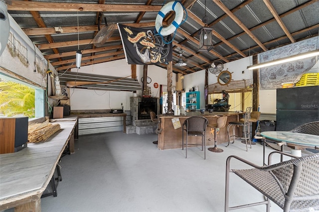 interior space featuring lofted ceiling, a workshop area, and concrete floors