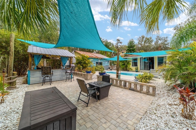 view of patio / terrace with a fire pit, an outdoor pool, and outdoor dry bar