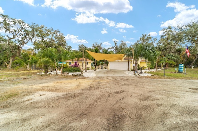 view of front facade with an attached garage and dirt driveway