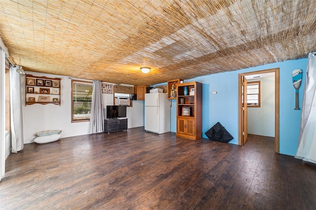 unfurnished living room featuring wooden ceiling, plenty of natural light, and dark wood-style floors