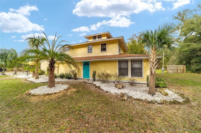 view of front of home with a front yard and fence