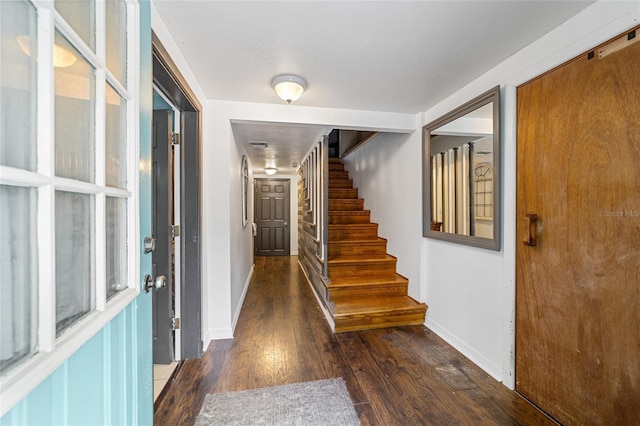 entryway with stairs, baseboards, and wood finished floors