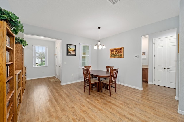 dining space with a chandelier and light hardwood / wood-style floors