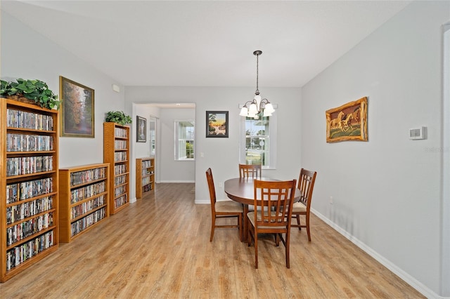 dining room with light hardwood / wood-style flooring and a notable chandelier