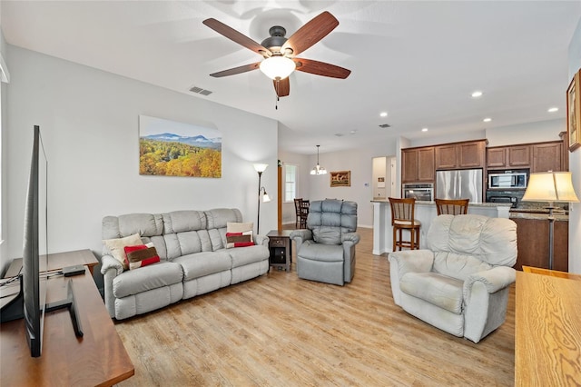 living room featuring ceiling fan and light hardwood / wood-style flooring