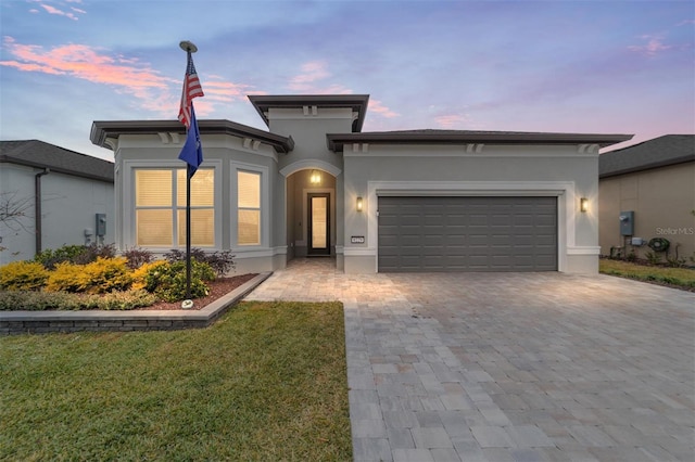 view of front of home with a garage and a lawn