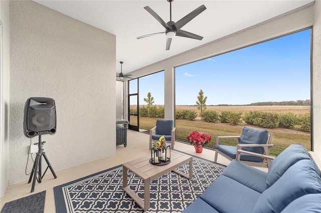 sunroom / solarium featuring ceiling fan and a rural view