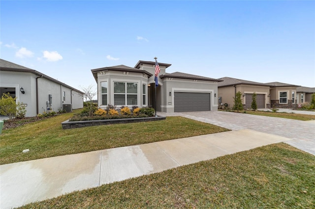 prairie-style home with a front lawn, central air condition unit, and a garage