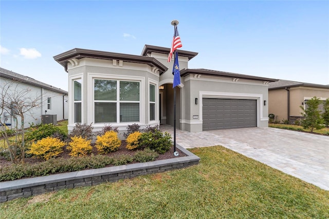 view of front of house featuring a front lawn, cooling unit, and a garage