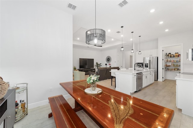 dining area with a raised ceiling and sink