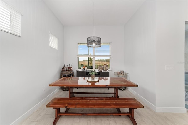 dining room with light hardwood / wood-style flooring and a chandelier