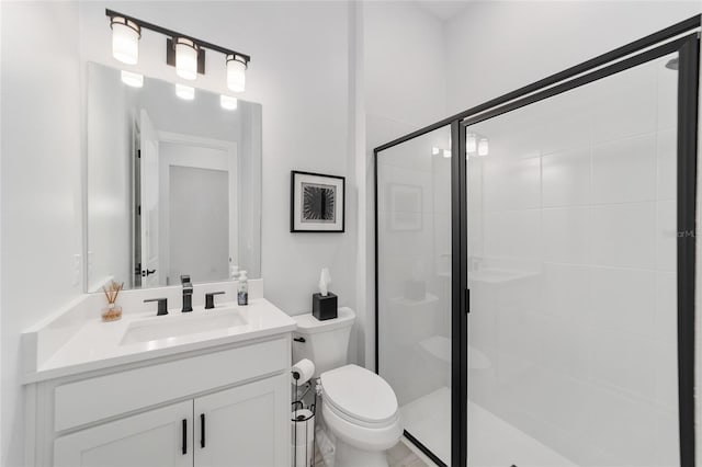 bathroom with an enclosed shower, vanity, and toilet