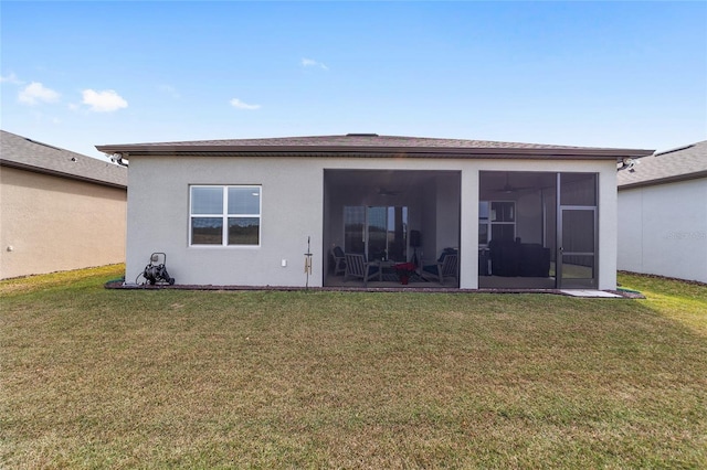 rear view of house featuring a sunroom and a lawn