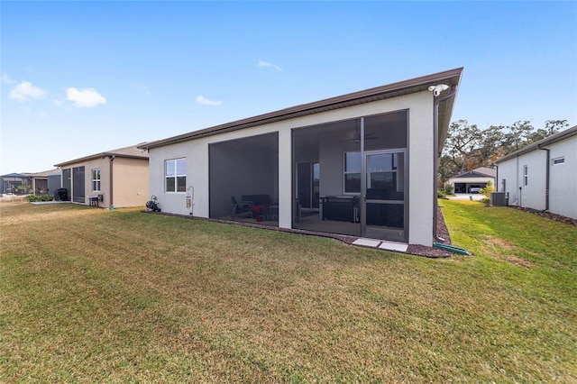 back of property featuring central air condition unit, a yard, and a sunroom