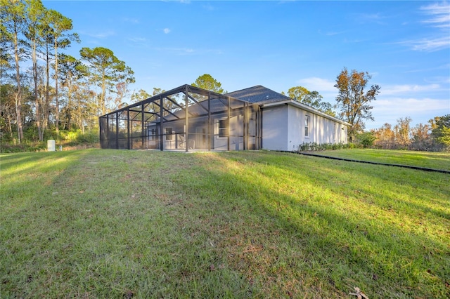 back of house featuring glass enclosure and a yard