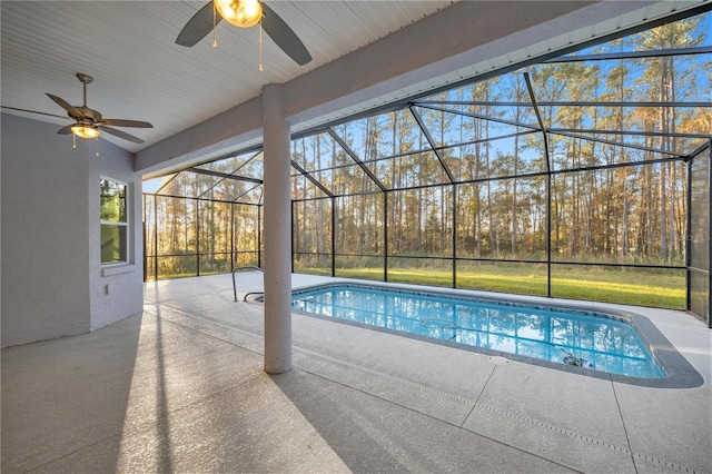 view of pool featuring glass enclosure, ceiling fan, and a patio