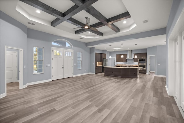 unfurnished living room featuring beamed ceiling, ceiling fan, wood-type flooring, and coffered ceiling