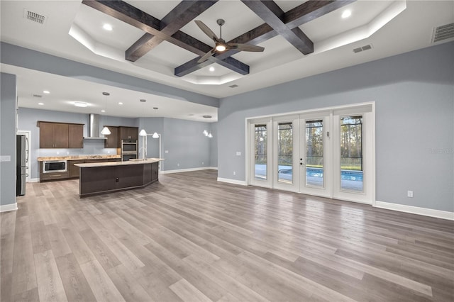 kitchen featuring decorative light fixtures, beam ceiling, a kitchen island with sink, and coffered ceiling