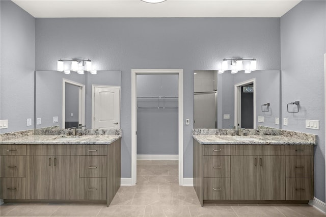 bathroom featuring tile patterned flooring, vanity, and walk in shower