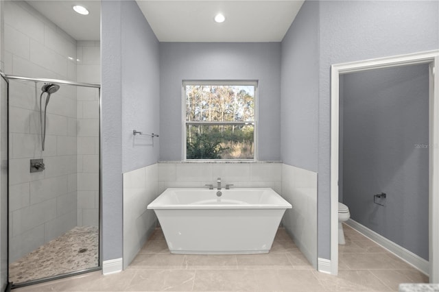 bathroom with shower with separate bathtub, toilet, and tile patterned floors