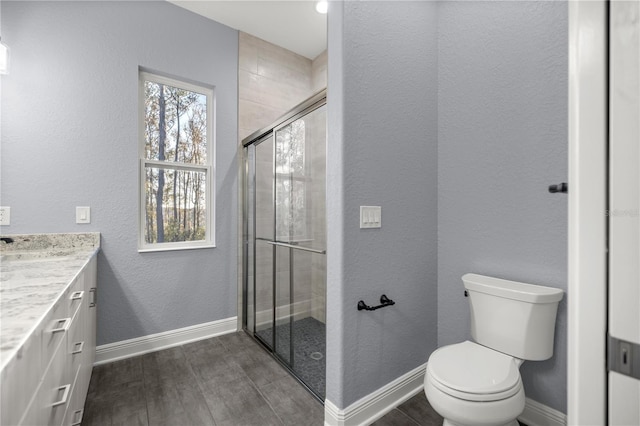 bathroom with hardwood / wood-style flooring, vanity, toilet, and a shower with door