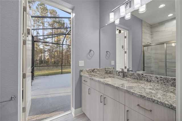 bathroom featuring vanity and a shower with door