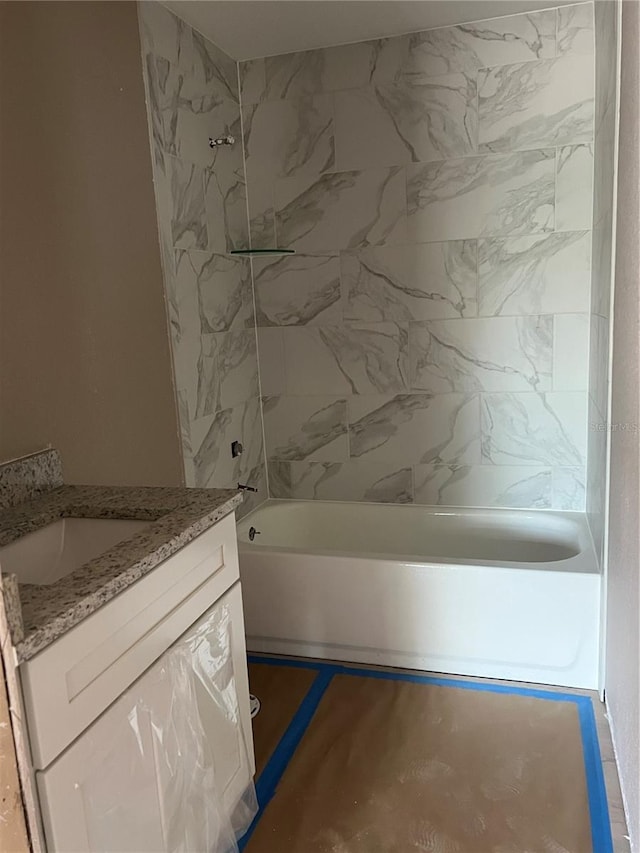 bathroom with tiled shower / bath and vanity